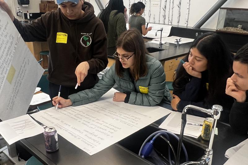 Photo of high school student researchers examining data