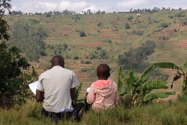A young student takes a reading assessment in the hills of the Gicumbi district in rural Rwanda (Photo by Elliott Friedlander)