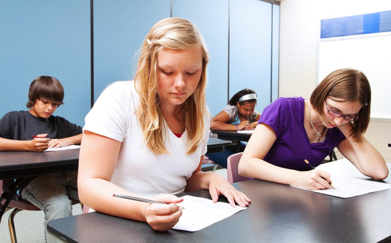 Young teenagers taking an exam.